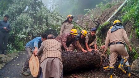 Firefighters clear debris from a blocked road after a landslide, in Shimla, Sunday, Aug. 31, 2025.