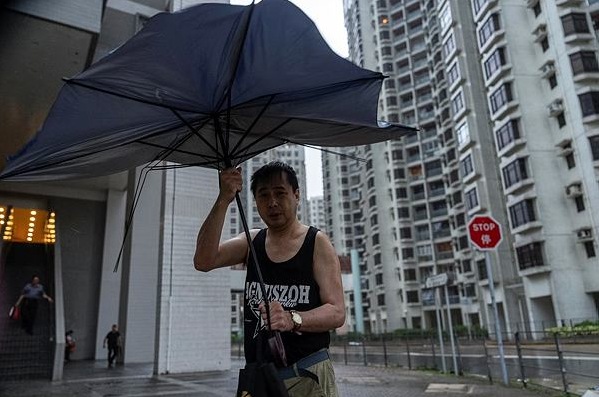 A pedestrian holds umbrella under strong wind in Heng Fa Chuen area as Super Typhoon Ragasa approaches in Hong Kong