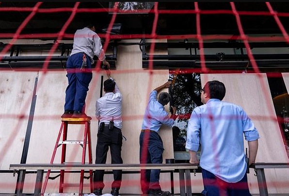 Workers install protective barriers at a restaurant ahead of the super typhoon Ragasa approaching Hong Kong.