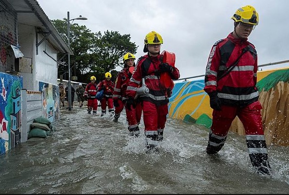 Firefighters walk through the floodwaters in Lei Yue Mun area as super typhoon Ragasa approaches in Hong Kong,