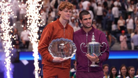 Jannik Sinner, of Italy, left, and Carlos Alcaraz, of Spain, right, hold their trophies after Alcaraz defeated Sinner to win the men's singles final of the U.S. Open tennis championships, Sunday, Sept. 7, 2025, in New York. (AP Photo/Frank Franklin II)