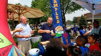 Ben Cohen, second from left, and Jerry Greenfield, center, founders of Ben & Jerry Homemade Inc., serve ice cream to Washington residents (AP Photo/Nick Wass)