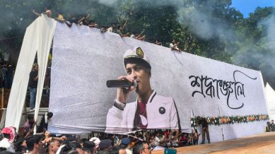People look from atop a banner during the funeral of singer Zubeen Garg, on the outskirts of Guwahati, Tuesday, Sept. 23, 2025. Zubeen Garg died while scuba diving in Singapore. (PTI Photo)