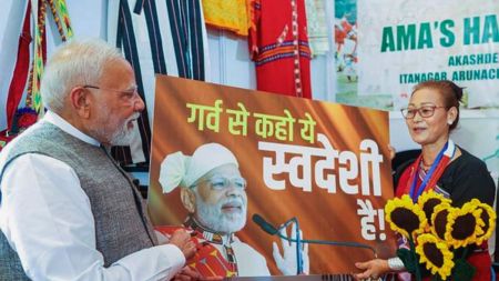 Itanagar, Sep 22 (ANI): Prime Minister Narendra Modi greeted with 'Garv Se Swadeshi' banner by a retailer, upon his visit to a stall in an exhibition, in Itanagar, on Monday (DPR PMO/ANI Photo)
