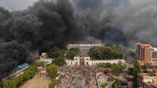 Protesters celebrate at the parliament building after it was set on fire during a protest against social media ban and corruption in Kathmandu, Nepal, Tuesday, Sept. 9, 2025. (AP Photo)