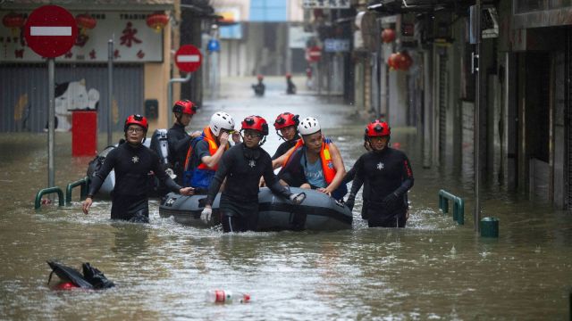 In this photo released by Xinhua News Agency, members from the local customs authority help stranded citizens to evacuate from an inundated street as Super typhoon Ragasa past nearby Macao in southern China, Sept. 24, 2025. (Cheong Kam Ka/Xinhua via AP)