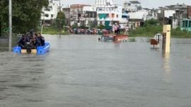 Fire teams attempt to rescue two men stranded in a tanker in Jambuva village on the outskirts of Vadodara city on Sunday after the Jambuva river floods the area. (Express Photo)