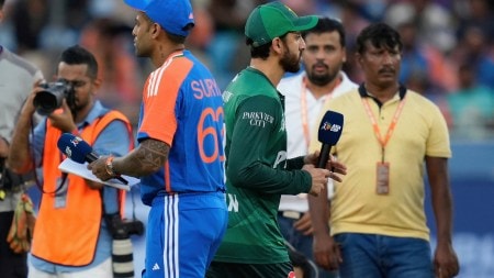 Pakistan's captain Salman Agha, right, walks past India's captain Suryakumar Yadav after the coin toss ahead of the Asia Cup cricket match between India and Pakistan at Dubai International Cricket Stadium in Dubai, United Arab Emirates, Sunday, Sept. 14, 2025. (AP Photo)