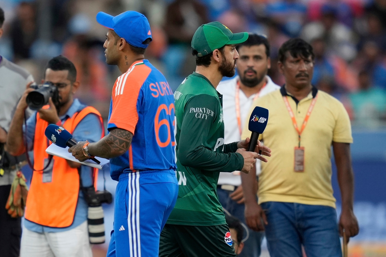 Pakistan's captain Salman Agha, right, walks past India's captain Suryakumar Yadav after the coin toss before the Asia Cup match between the two teams on September 14. (AP Photo)