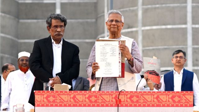 Head of the Bangladesh's interim government and Nobel laureate Dr. Muhammad Yunus, center right, displays a political charter called 'July National Charter' at an event outside Bangladesh's national parliament complex in Dhaka, Bangladesh, Friday, Oct. 17, 2025. (AP Photo/Mahmud Hossain Opu)