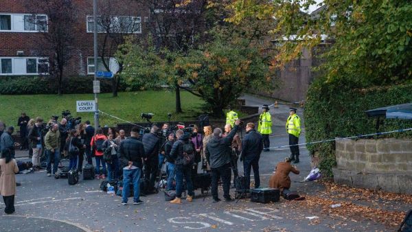 Members of the media near police officers guarding the scene of a stabbing at Heaton Park Hebrew Congregation synagogue in Manchester. (Andrew Testa/The New York Times)