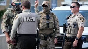 Federal Patrol agents and Cook County Sheriff's police stand near the entrance of an ICE (U.S. Immigration and Customs Enforcement) processing facility in the Chicago suburb of Broadview, Ill., Monday, Oct. 6, 2025. (AP Photo/Nam Y. Huh)
