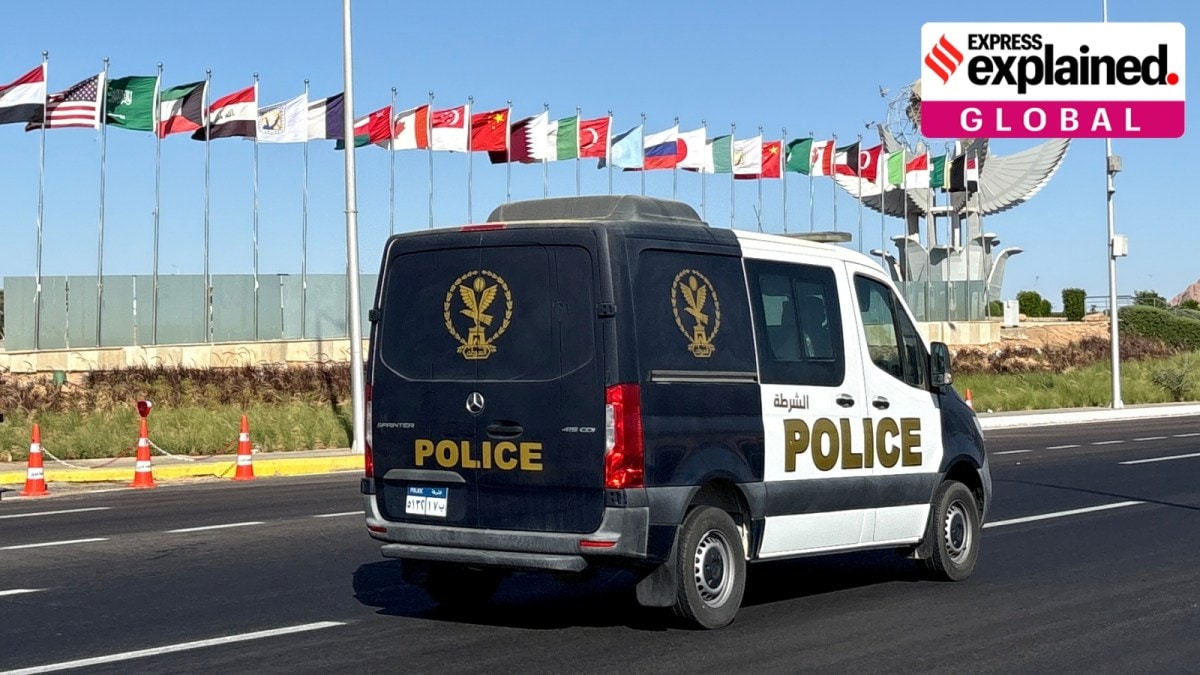 A police vehicle passes past flags of participating countries at a summit hosted by the Egyptian government to celebrate the signing Israel-Hamas ceasefire deal at the Red Sea city of Sharm el-Sheikh, Egypt, Sunday, October 12, 2025. (AP Photo)