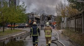 Firefighters walk towards a warehouse that caught fire following a Russian attack, Saturday, Oct. 25, 2025, in Kyiv, Ukraine. (AP Photo/Julia Demaree Nikhinson)