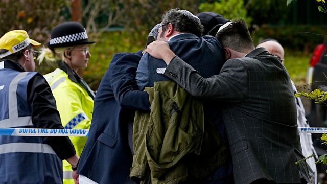 Members of the Jewish community comfort each other near to the Heaton Park Hebrew Congregation synagogue, in Crumpsall, Manchester, England, Thursday, Oct. 2, 2025 after Police reported that two people were killed and three others were seriously injured in a synagogue attack in northern England. (Peter Byrne/PA via AP)