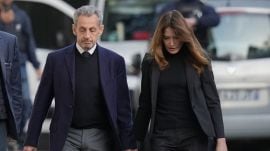Former French President Nicolas Sarkozy and his wife Carla Bruni-Sarkozy leave their home Tuesday, Oct. 21, 2025 in Paris