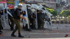 Police personnel take cover behind shields to save themselves from stones thrown by supporters of Islamist party 'Tehreek-e-Labbaik Pakistan' during clashes ahead of their pro-Palestinian march toward capital Islamabad, in Lahore, Pakistan, Friday, Oct. 10, 2025. (AP Photo/K.M. Chaudary)