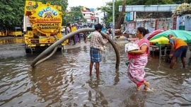 A worker unclogs drain on a waterlogged road following rains, in Chennai, Tuesday, Oct. 21,
