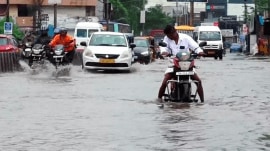 Tamil Nadu Cyclone alert: Commuters make their way through a waterlogged road following heavy rainfall in Avadi, Tamil Nadu, on Wednesday (Photo: PTI).