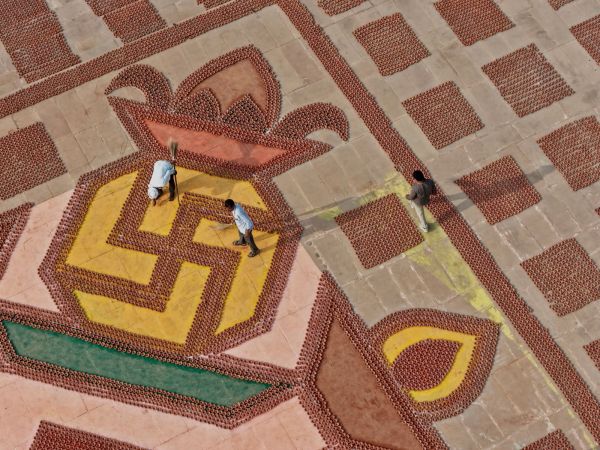 Volunteers clean near geometric patterns of earthen lamps in Ayodhya (AP Photo)