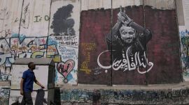 A man walks past a mural depicting the Palestinian leader Marwan Barghouti, with a message that reads in Arabic, "See you soon,” on Israel's separation barrier in the West Bank city of Bethlehem, Aug. 20, 2025. (AP Photo/Mahmoud Illean, File)