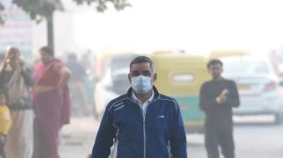 A man wears a mask amid smog as the Air Quality Index (AQI) remains in poor category, near ISBT in New Delhi (Photo credit: PTI )