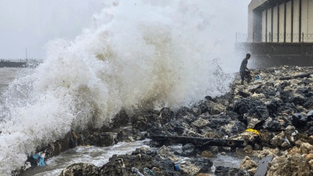 Ramanathapuram: A man stands on rocks as waves crash against the seaside during rough sea conditions triggered by Cyclone Ditwah, in Ramanathapuram, Tamil Nadu, Friday, Nov. 28.