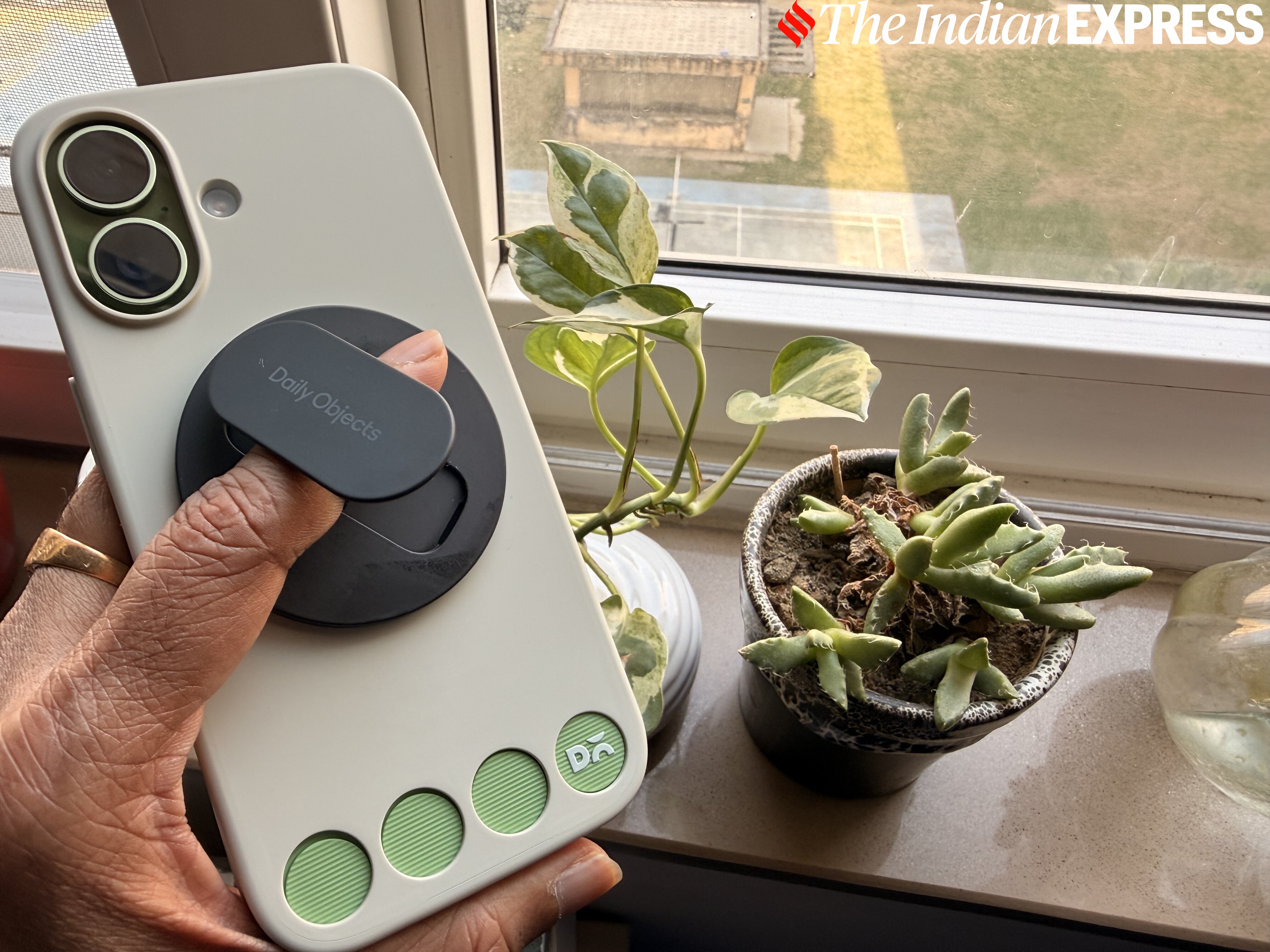 The black MagSafe grip and stand sticks to the back of the iPhone like an acolyte.