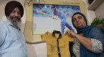 India captain Harmanpreet Kaur's parents Harmandar Singh Bhullar and Satwinder Kaur with the infant Harman's "GOOD BATTING" shirt during the coversation with Indian Express at home in Moga. (Express Photo by Gurmeet Singh)