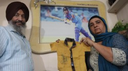 India captain Harmanpreet Kaur's parents Harmandar Singh Bhullar and Satwinder Kaur with the infant Harman's "GOOD BATTING" shirt during the coversation with Indian Express at home in Moga. (Express Photo by Gurmeet Singh)