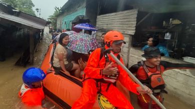 In this photo released by the Indonesian National Search and Rescue Agency (BASARNAS), rescuers on a rubber boat evacuate residents from their flooded home in North Sumatra province, Indonesia Tuesday, Nov. 25, 2025. (BASARNAS via AP)