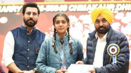 Patiala: Punjab Chief Minister Bhagwant Mann, right, and actor Binnu Dhillon, left, distribute a tablet to a student during an event organised at the Punjabi University, in Patiala, Thursday, Nov. 27, 2025. (PTI Photo) (PTI11_27_2025_000392B)