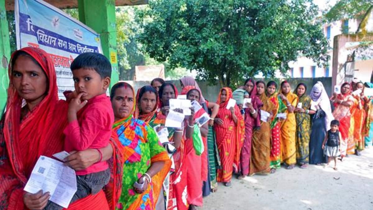 Voters wait in a queue to cast their votes at a polling booth during the second and final phase of the Bihar Assembly elections
