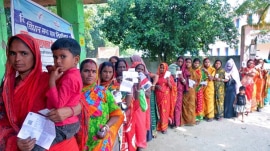 Voters wait in a queue to cast their votes at a polling booth during the second and final phase of the Bihar Assembly elections