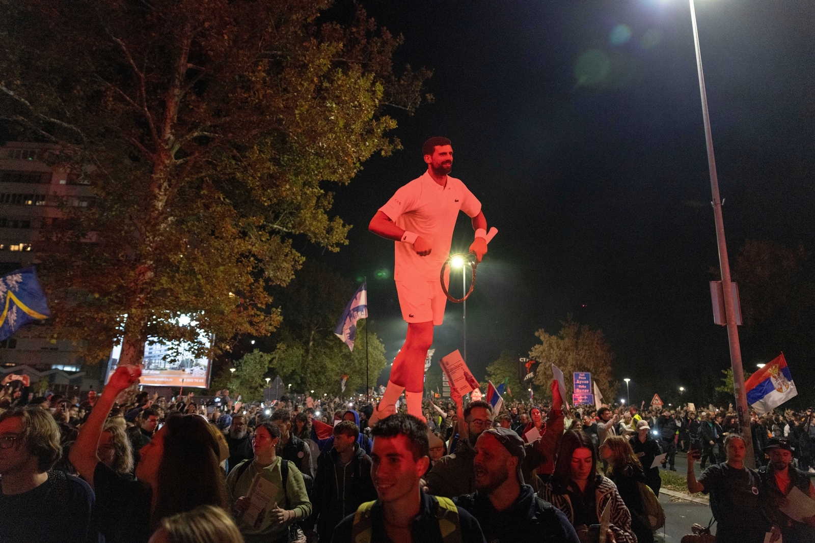 Protesters carry a cardboard cutout of Novak Djokovic as they arrive before a rally on Nov. 1 marking the first anniversary of a train station disaster that killed 16 people, in Novi Sad, Serbia. (AP Photo)