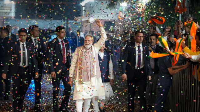 New Delhi: Prime Minister Narendra Modi waves a ‘gamcha’ as he arrives during the celebration of NDA’s victory in the Bihar Assembly elections, at BJP headquarters, in New Delhi, Friday, Nov. 14, 2025. Union Health Minister and BJP National President JP Nadda is also seen. (PTI Photo/Ravi Choudhary) (PTI11_14_2025_000411A)