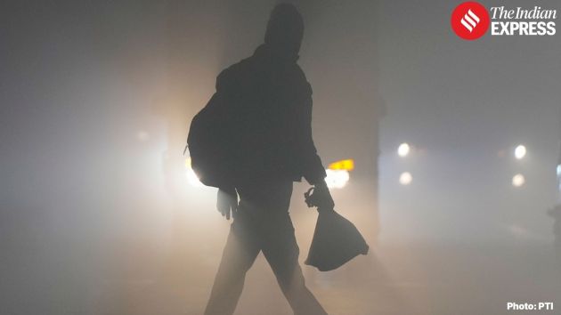 Silhouettes of pedestrians emerging through the dense haze