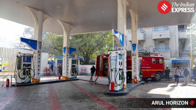 Firefighters work near a petrol pump situated close to the site of the blaze