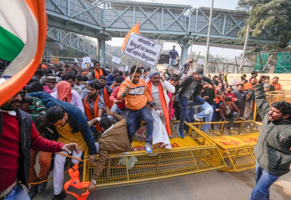Vishwa Hindu Parishad (VHP) and Bajrang Dal members walk over barricades during a protest near the Bangladesh High Commission over attacks on Hindus in the neighbouring country.