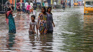 Chennai Weather Today: People wade through knee-dipped road following Cyclone Ditwah, in Chennai, Tuesday, Dec. 2, 2025.
