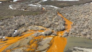 In an image provided by the USGS, A tributary of the Kugaaruk River in northern Alaska turning orange from elevated heavy metal concentrations. Record-setting temperatures and rainfall in the Arctic over 2025 sped up the melting of permafrost and washed toxic minerals into more than 200 rivers across northern Alaska, threatening vital salmon runs, according to a report card issued by federal scientists. (Image: The New York Times)