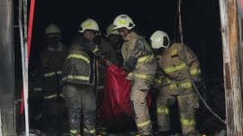 Rescuers carry out the body of a victim from the site of a fire in Jakarta, Indonesia, Tuesday, Dec. 9, 2025. (AP Photo/Dita Alangkara)