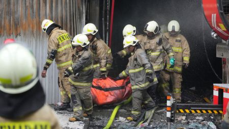 Rescuers carry out the body of a victim from the site of a fire in Jakarta, Indonesia, Tuesday, Dec. 9, 2025. (AP Photo/Dita Alangkara)