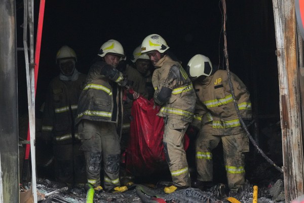 Rescuers carry out the body of a victim from the site of a fire in Jakarta, Indonesia, Tuesday, Dec. 9, 2025. (AP Photo/Dita Alangkara)