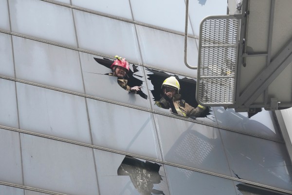 Firefighters work in an office building that caught fire in Jakarta, Indonesia, Tuesday, Dec. 9, 2025. (AP Photo/Dita Alangkara)