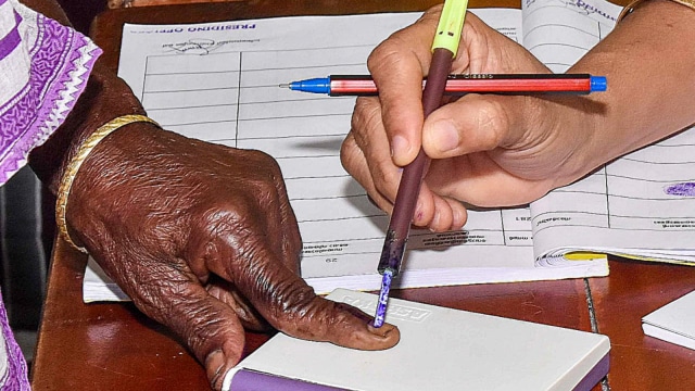  An elderly woman gets her finger marked with indelible ink as she casts vote at a polling booth during the second phase of the Kerala local body elections, in Wayanad district, Thursday, Dec. 11, 2025.