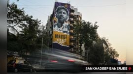 Vehicles drive past a building in Mumbai where graffiti of Lionel Messi has been drawn by artist Mooz Graffiti. (Express Photo/Sankhadeep Banerjee)