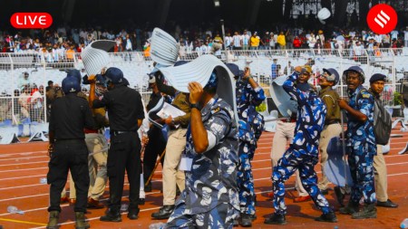 Lionel Messi India GOAT Tour Live Updates: Security forces take cover using broken chairs thrown on the pitch by angry fans at the Salt Lake Stadium pitch after the Argentine football legend left the Kolkata venue in 20 minutes today. (Express Photo by Partha Paul)