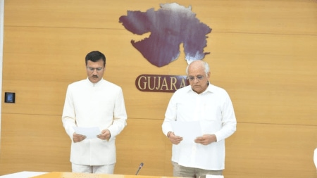 Pankaj Joshi (left), the newly appointed Chairperson of Guajrat Electricity Regulatory Commission being administered oath of office and secrecy by Chief Minister Bhupendra Patel. (Express photo)