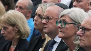 Australia's Prime Minister Anthony Albanese, center right, his wife Jodie Haydon, center left, and other guests participate in a ceremony to mark the National Day of Reflection for victims and survivors, at Bondi Beach in Sydney, Sunday, Dec. 21, 2025, following the Bondi shooting on Dec. 14. (AP Photo)